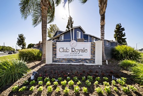 A sign for Club Royale in front of a building.