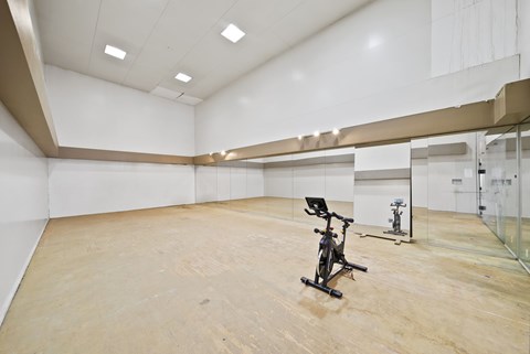 A room with a wooden floor and a wall with a window.