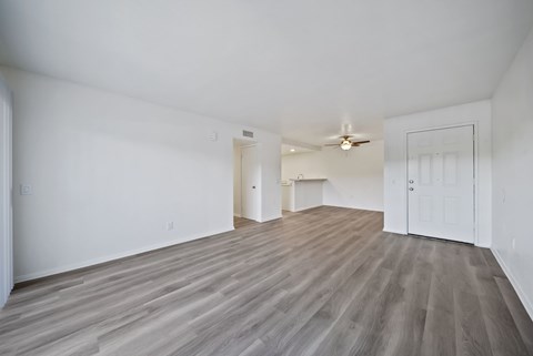 A room with wooden flooring and white walls.