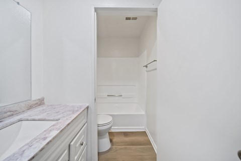 A white bathroom with a toilet, sink, and bathtub.