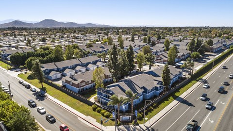 A street view of a residential area with houses and parked cars.