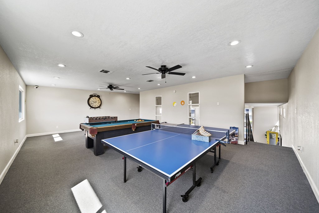 A room with a blue table and a pool table.