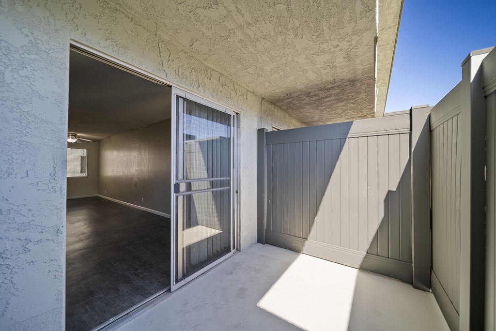 A room with a sliding glass door leading to a balcony.