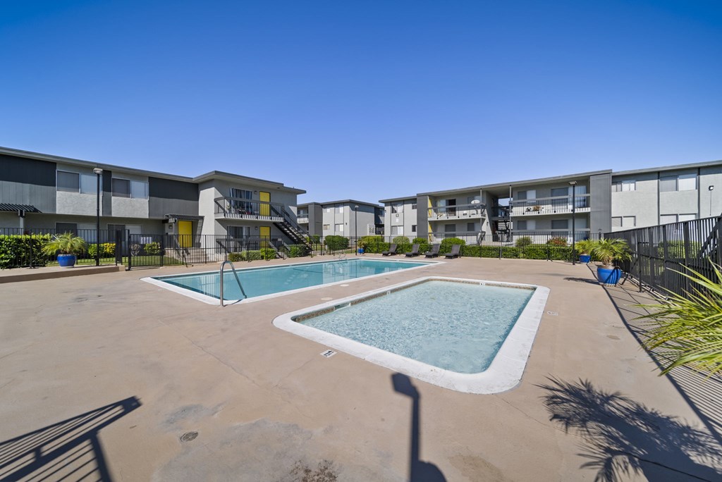 A swimming pool in front of apartment buildings.