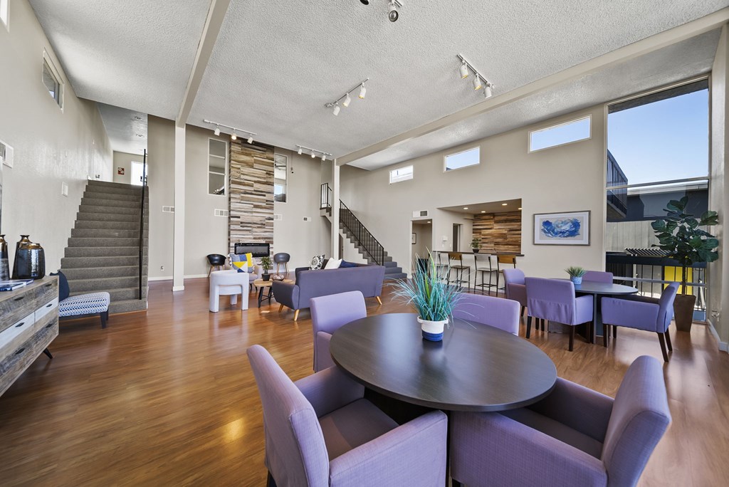 A large room with a round table and purple chairs.