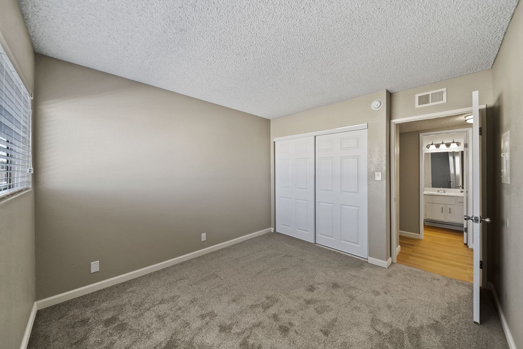 A room with a carpeted floor and a white door.