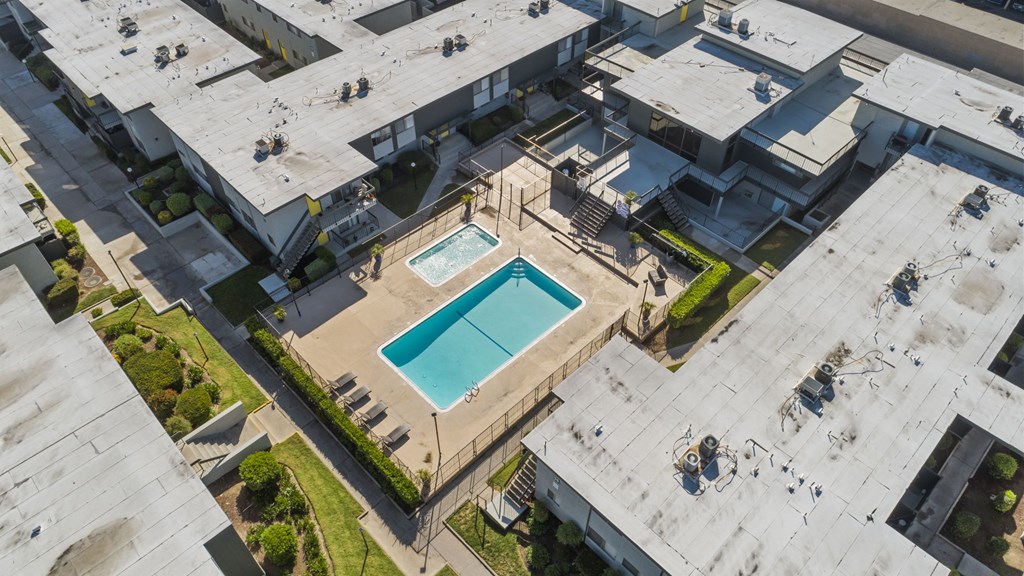 A swimming pool is surrounded by a concrete building.