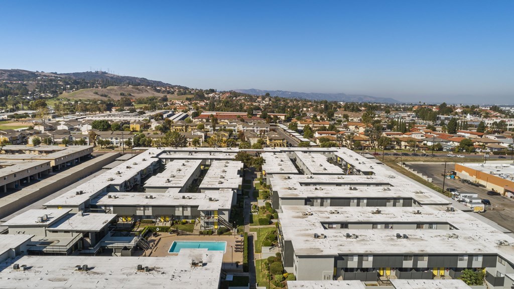 A large industrial area with multiple buildings and a pool in the foreground.