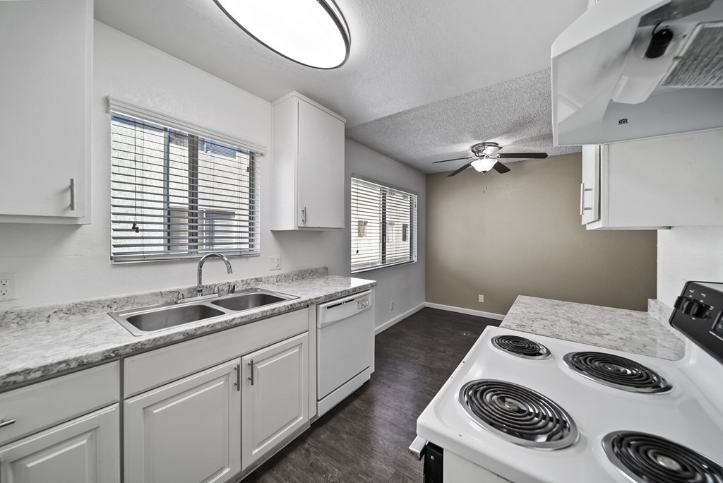 A kitchen with white cabinets and a stove top oven.