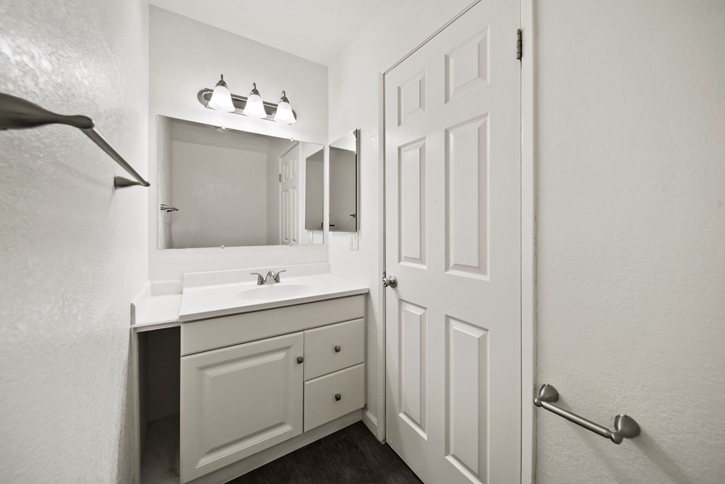 A white bathroom with a sink, mirror, and medicine cabinet.