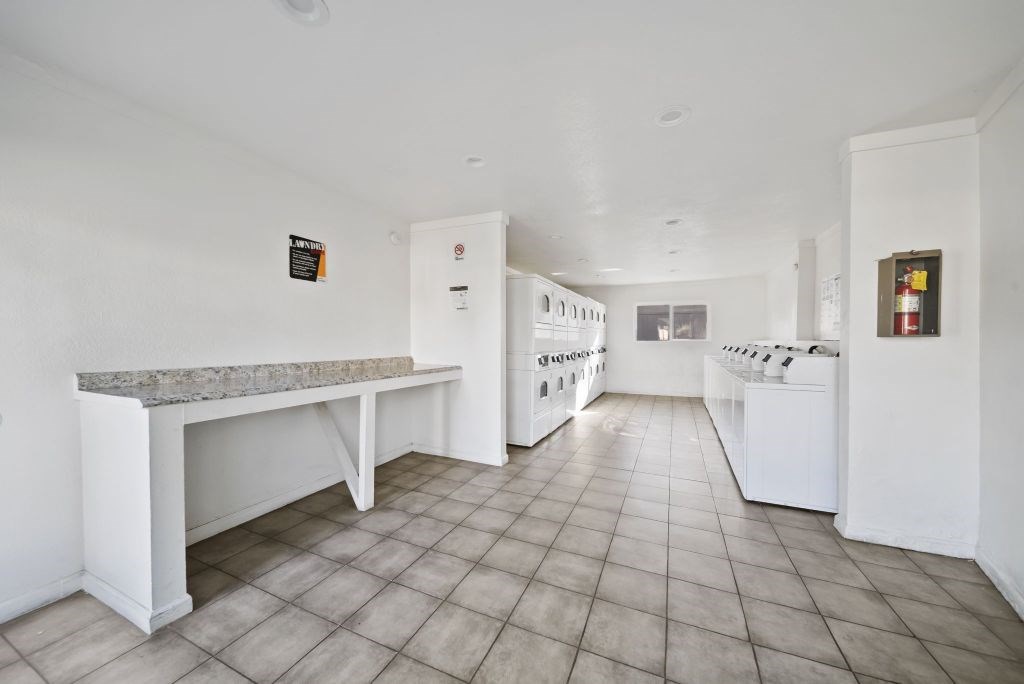 A kitchen with white appliances and a marble island.