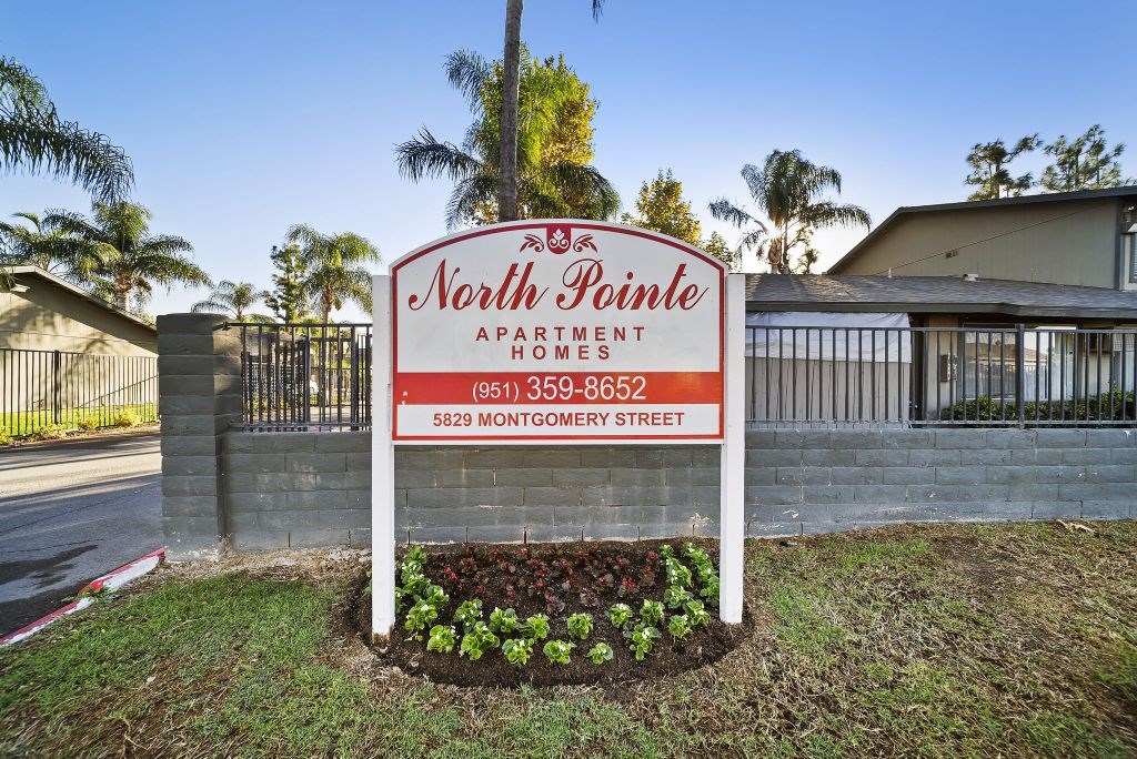 A sign for North Pointe Apartments is displayed in front of a building.