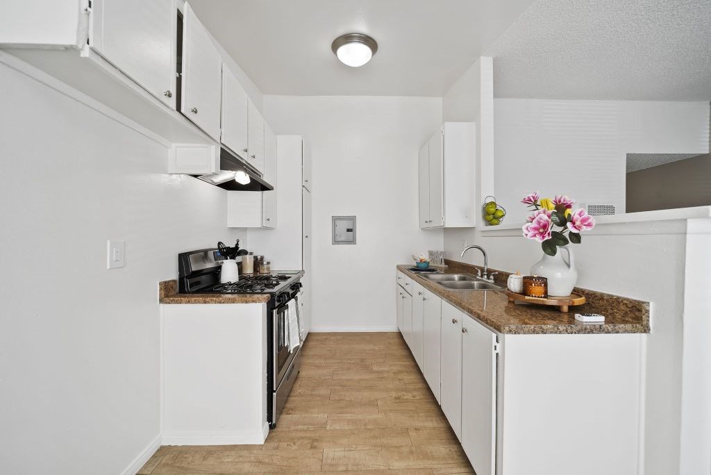 A kitchen with white cabinets and a granite countertop.
