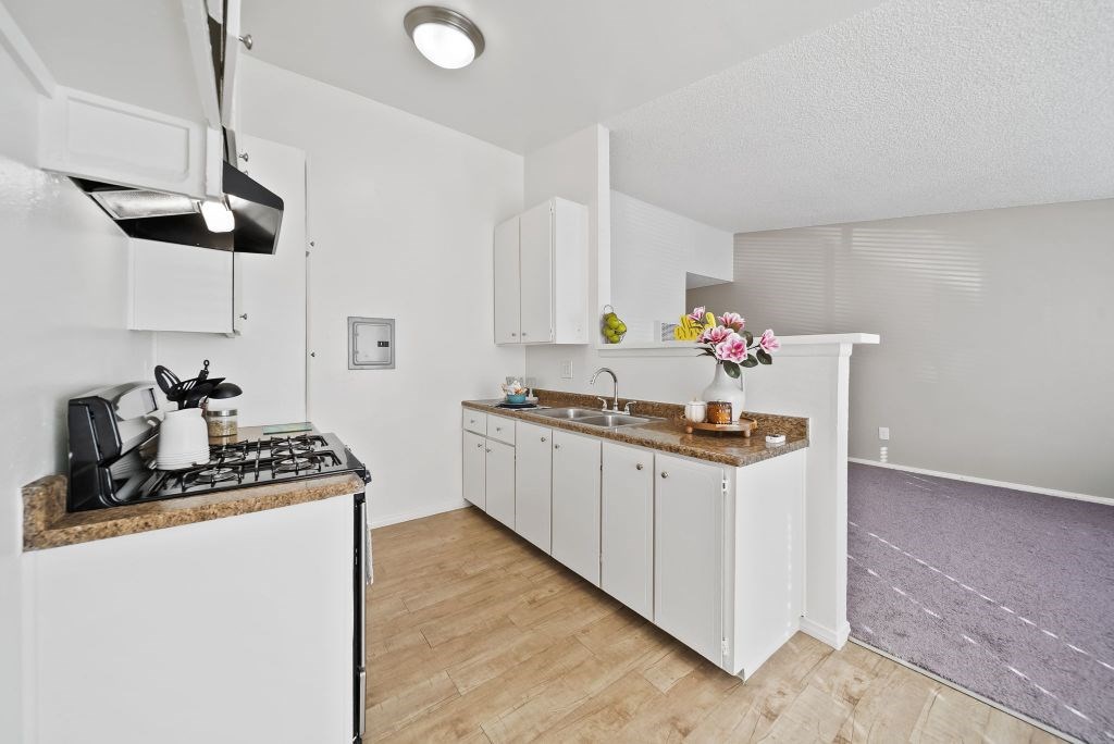 A kitchen with white cabinets and a granite countertop.