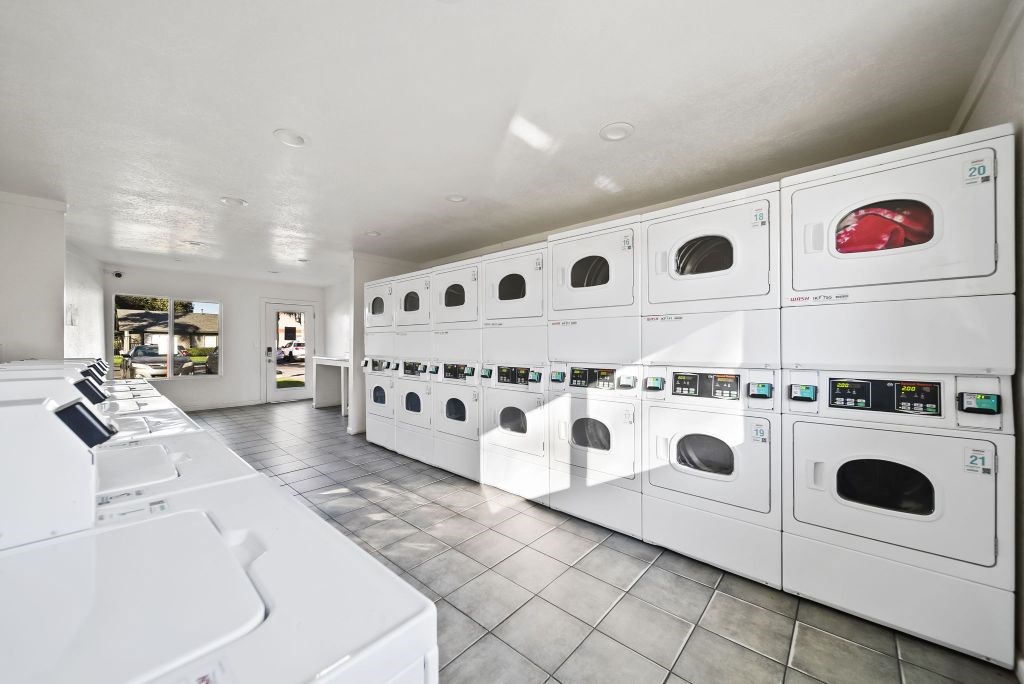 A row of white washing machines in a laundromat.