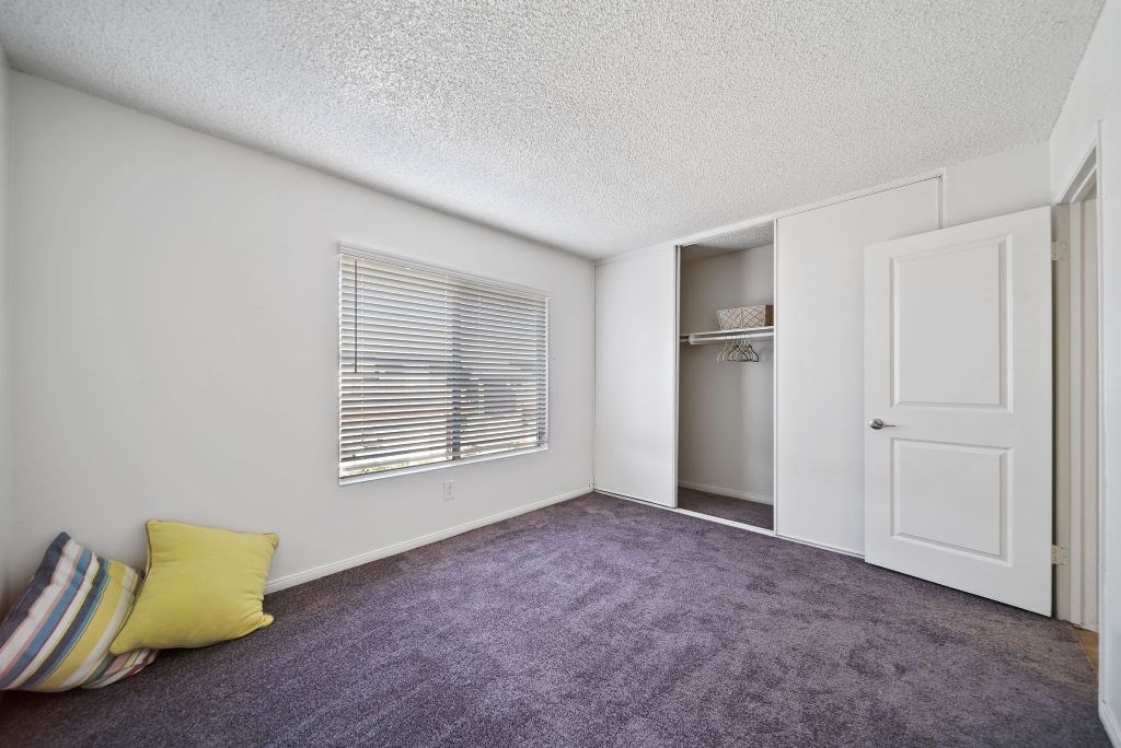 A room with a purple carpet and a white door.