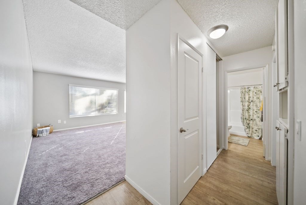 A hallway with a purple carpet and white walls.