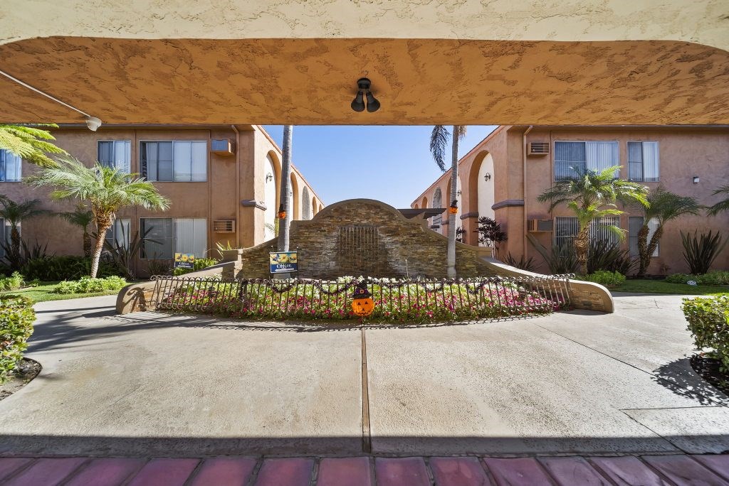 A view of a street with a building on the right and a building on the left.
