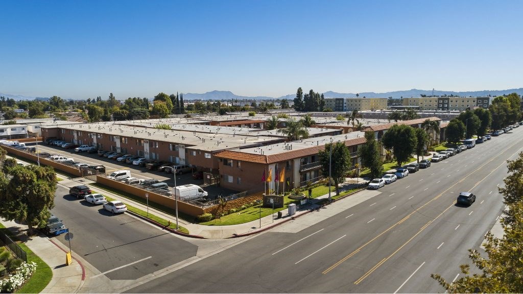 A street view of a residential area with cars parked on the side of the road.