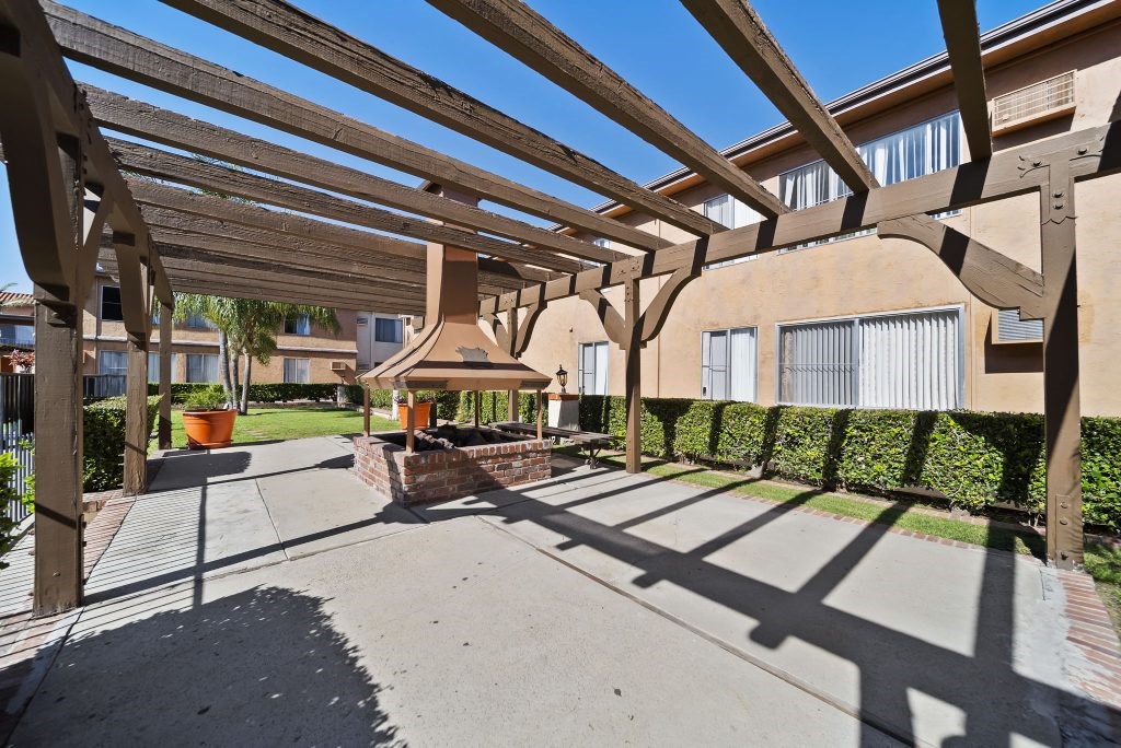 A wooden pergola over a walkway in a residential area.
