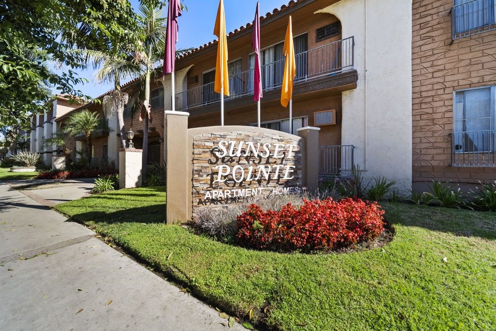 The sign in front of the building says Sunset Pointe Apartment Homes.