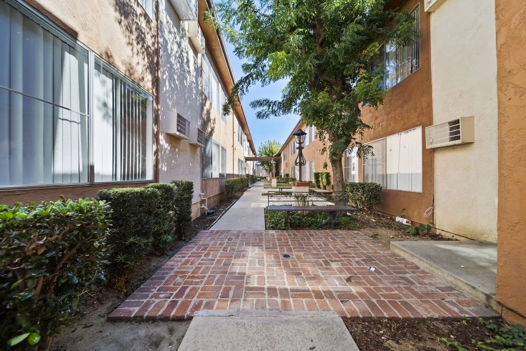 A long brick walkway leads between two buildings.