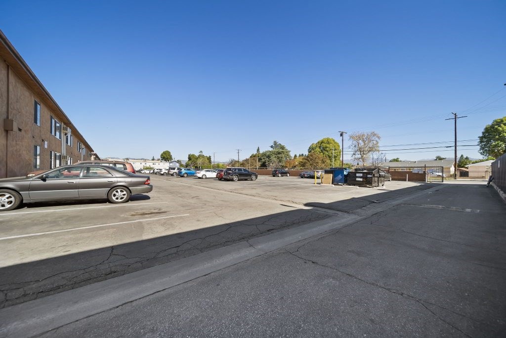 A parking lot with a car and a building in the background.