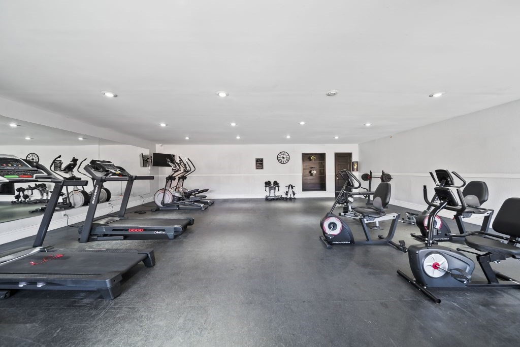 A gym with treadmills, exercise bikes, and other equipment.