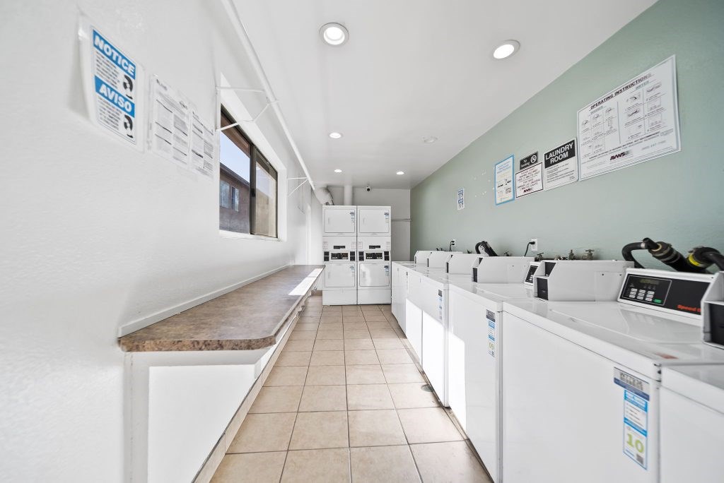 A clean, well-organized laundromat with rows of washers and dryers.