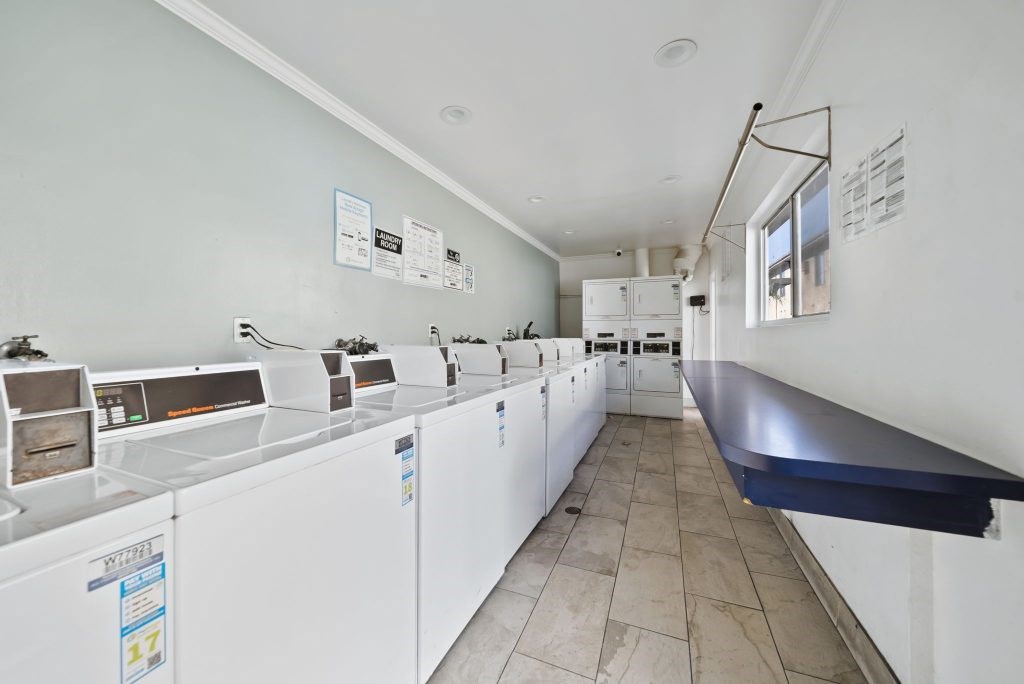 A laundromat with a row of washers and dryers.