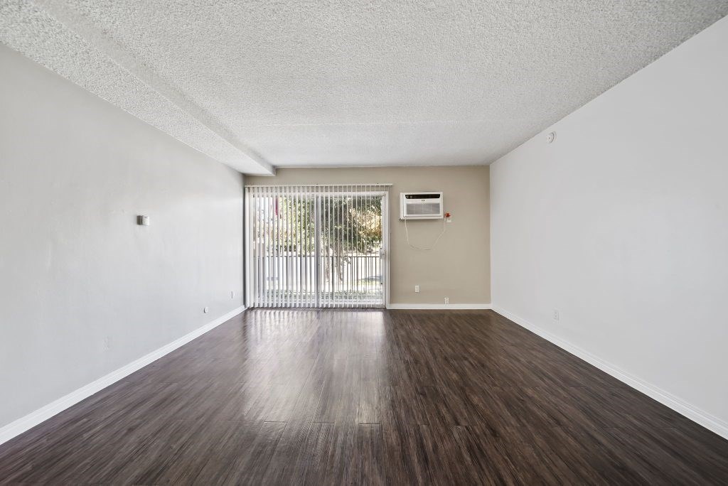 A room with a sliding door and wood flooring.