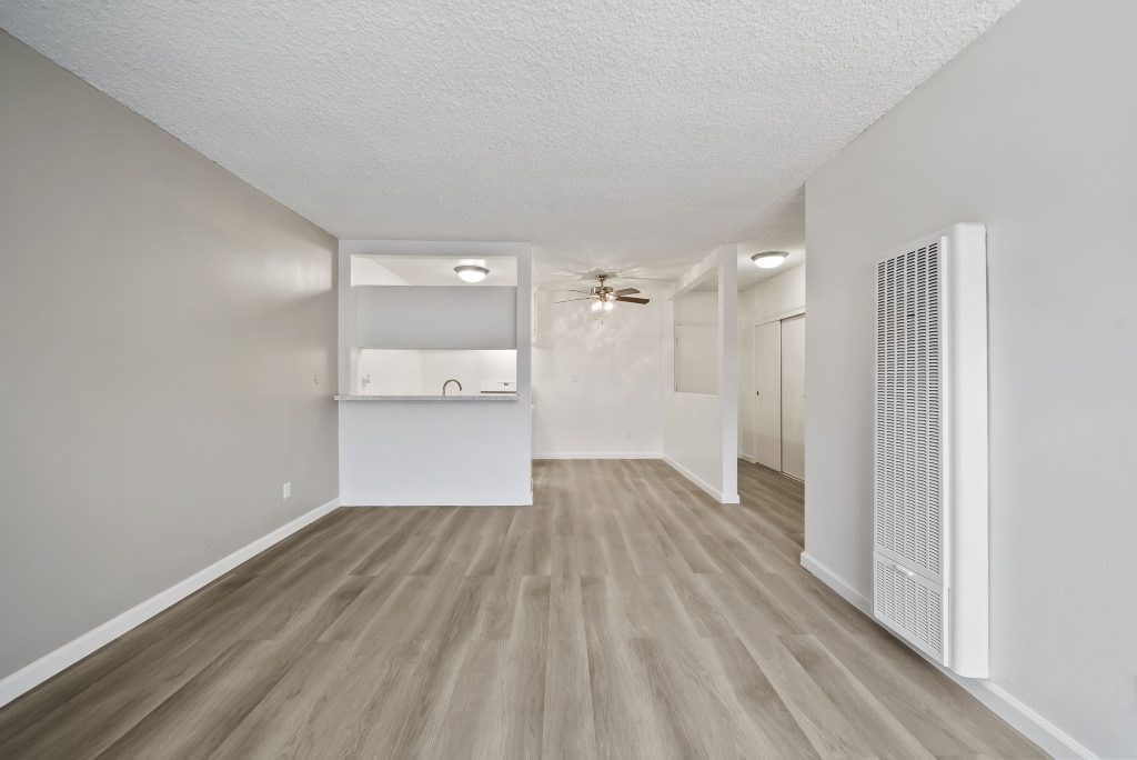 A room with light grey walls and wooden flooring with a white ceiling.