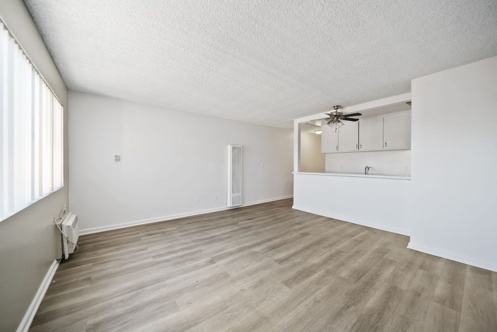 A room with a ceiling fan and light, and a window with blinds.