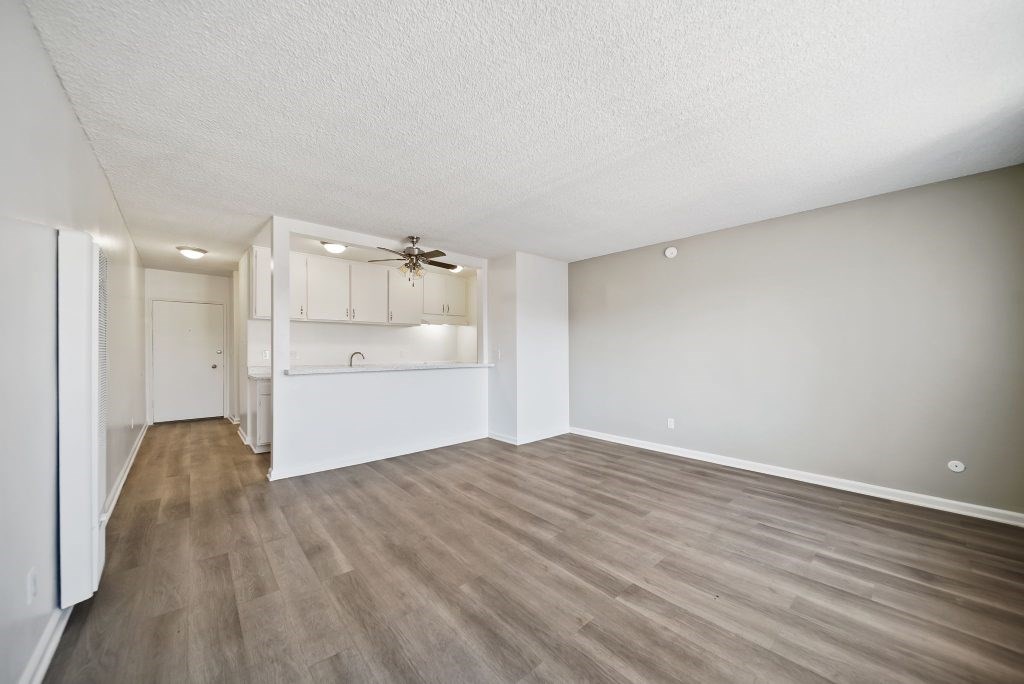 A room with a ceiling fan and light fixture, and a wall-mounted cabinet.
