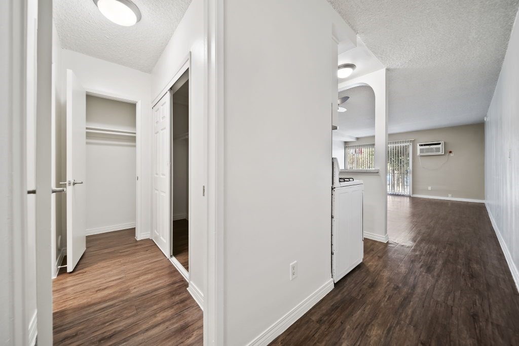 A long hallway with white walls and wood floors.