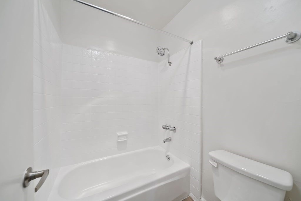 A white bathroom with a bathtub, toilet, and sink.