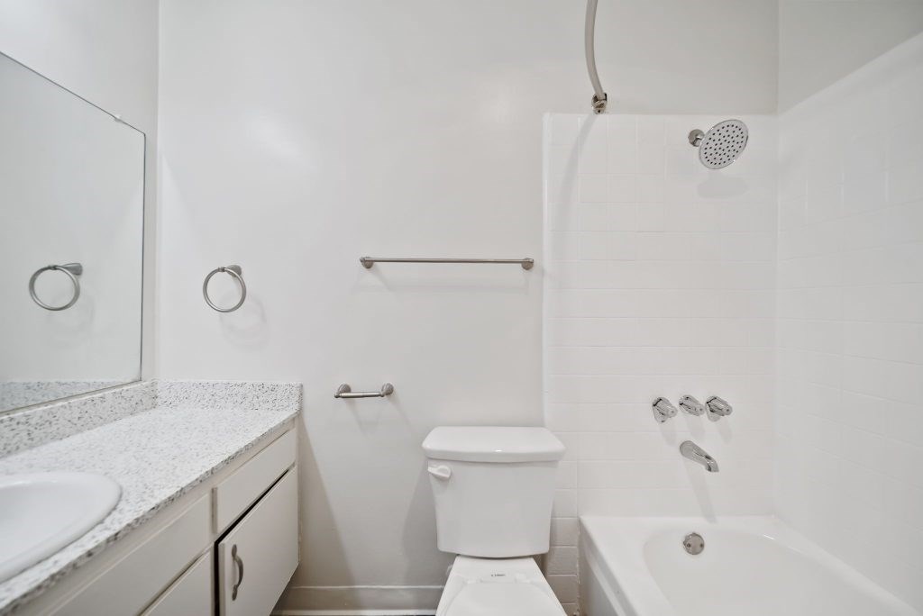 A white bathroom with a toilet, sink, and bathtub.