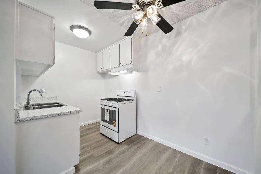 A kitchen with a white counter and a white oven.
