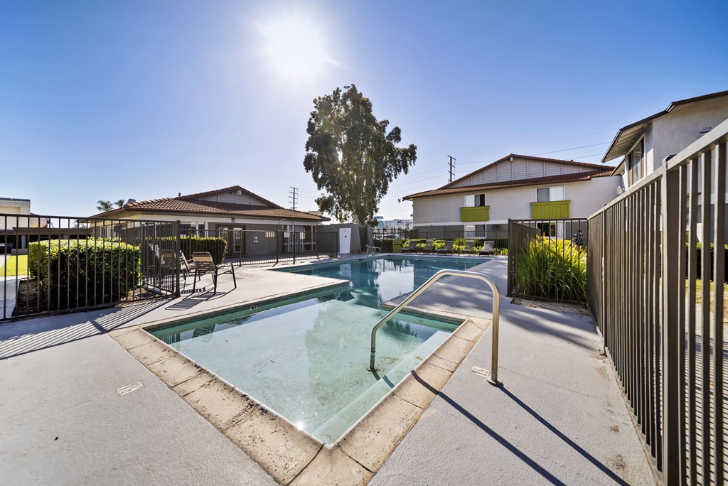 A sunny day at a pool with a fence on the right.