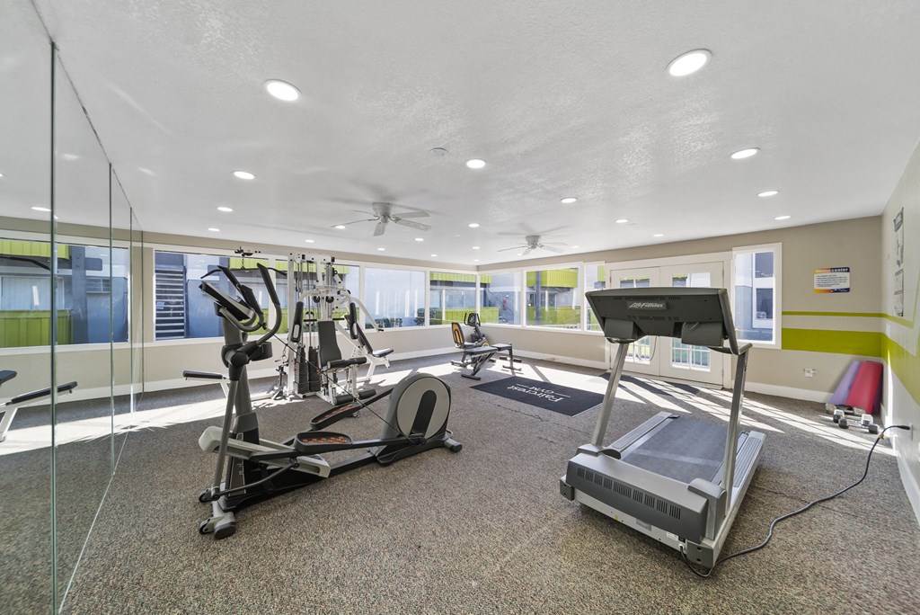 A gym with treadmills, elliptical machines, and other exercise equipment.