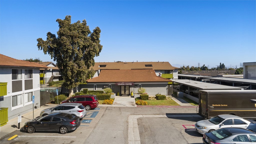 A parking lot with cars and a building in the background.