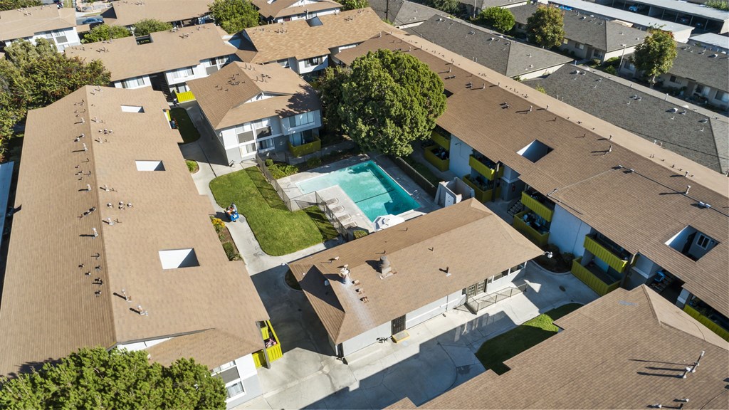 A bird's eye view of a residential area with houses and a swimming pool.