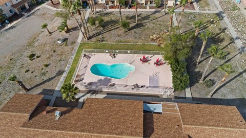 A swimming pool with a heart design in the middle of a backyard.