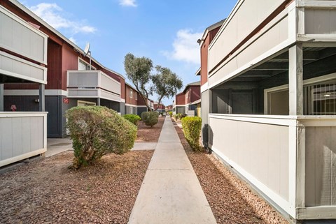 A long concrete walkway separates two rows of identical buildings.