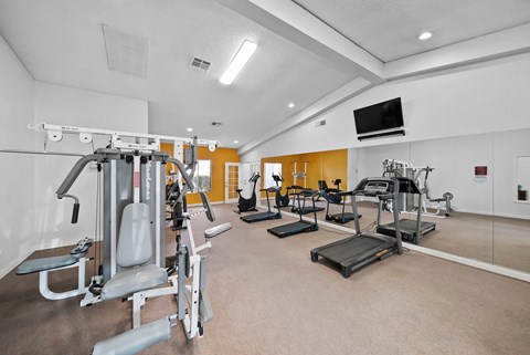 A well-equipped gym with various exercise machines.