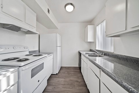 A modern kitchen with white appliances and cabinets.