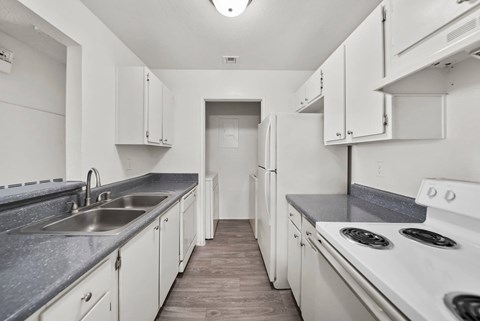 A kitchen with white cabinets and a stove top oven.