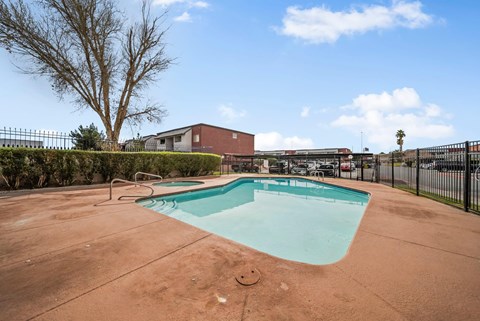 A small pool in a backyard with a fence around it.