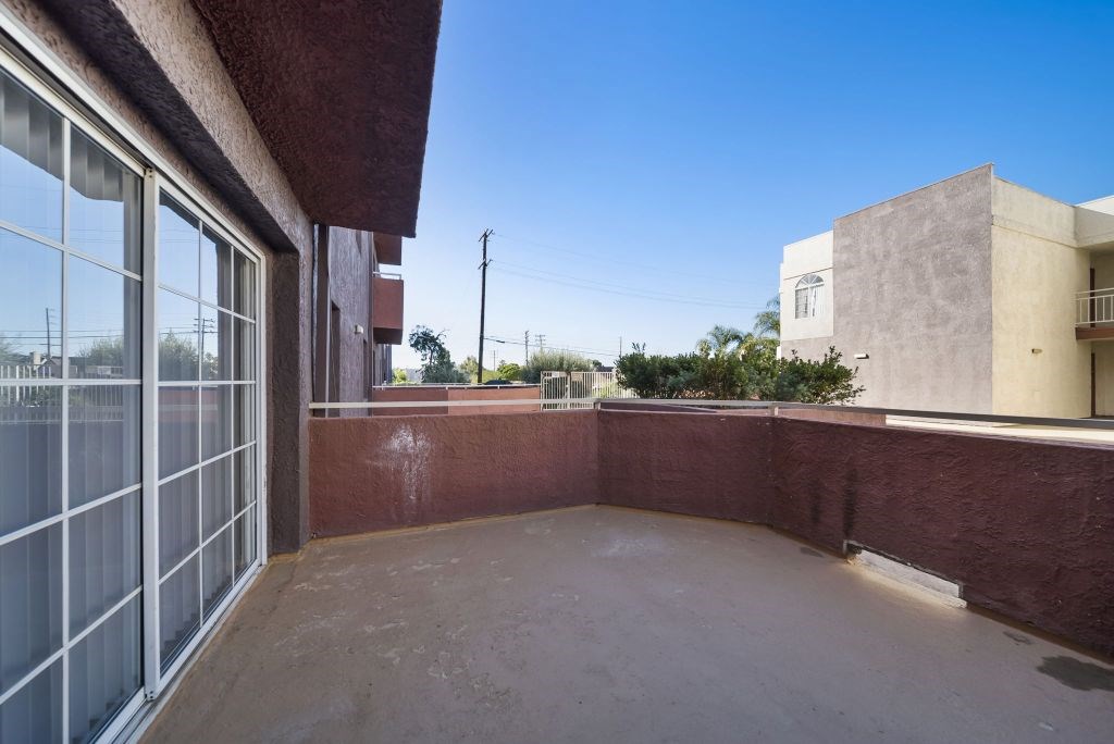 A patio with a red wall and a glass door.