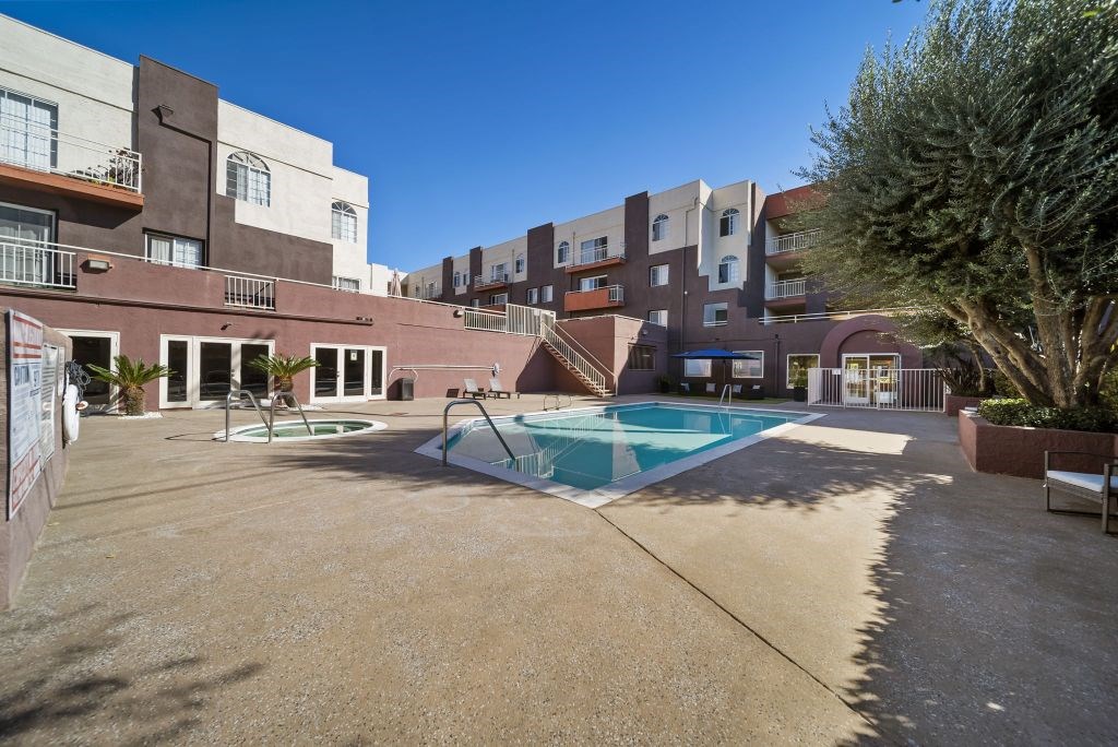 A large outdoor swimming pool surrounded by apartment buildings.